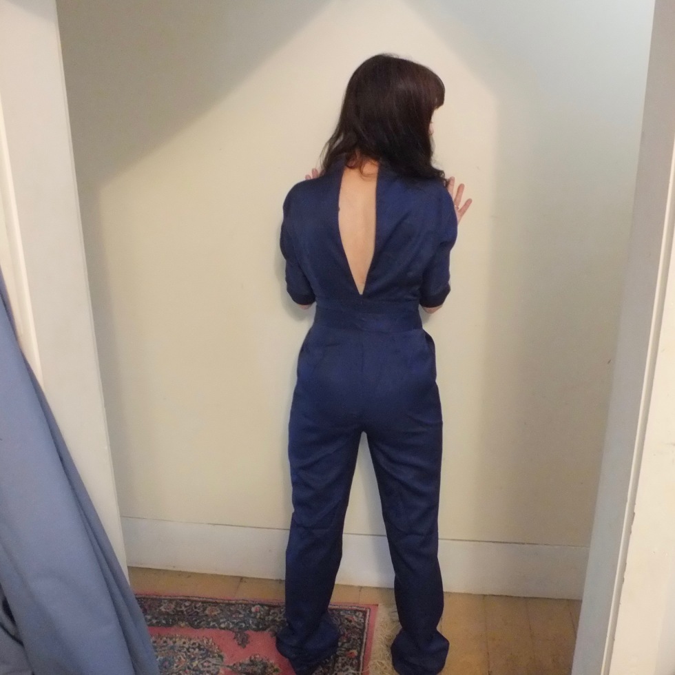 navy blue jumpsuit from an online Shanghai-based company called Rotital a woman with her back to the camera with a gaping zipper on the jumpsuit.